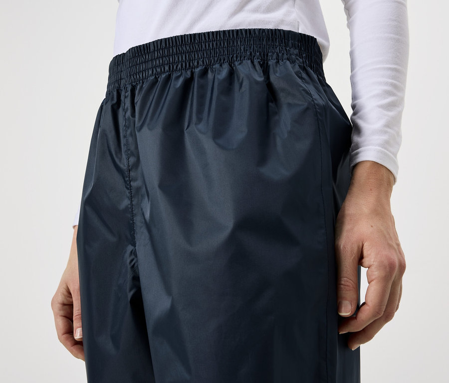 Person trägt dunkelblaue Regenhose mit elastischem Bund.