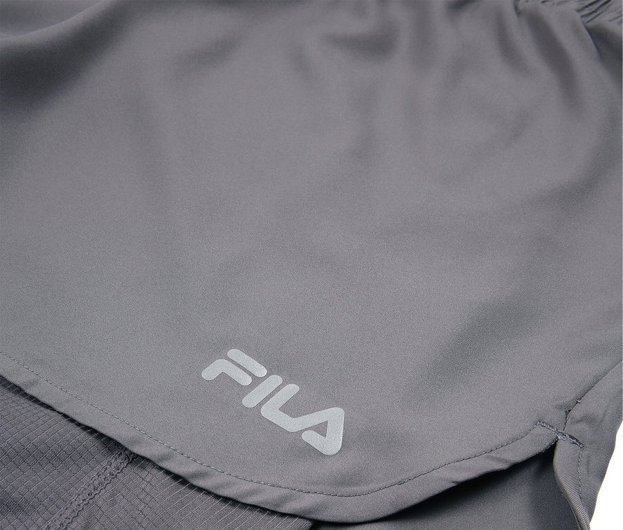 Nahaufnahme von grauen Fila-Shorts mit sichtbarem Fila-Logo.