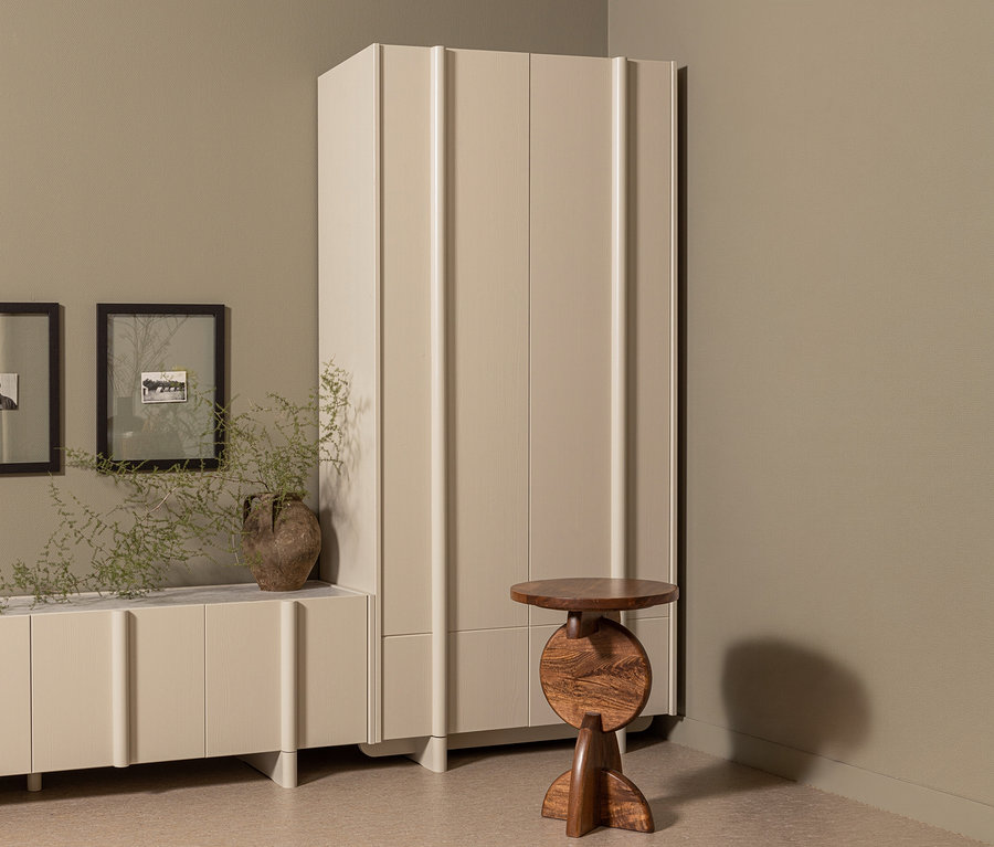 Ein WOOOD Lagerschrank »Basu« kiefer dust steht neben einem braunen Holztisch in einem Raum mit einem Sideboard und zwei gerahmten Bildern.