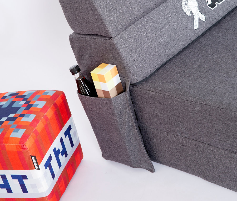 Nahaufnahme des roba Minecraft Gaming Sofas mit Getränk und Minecraft-Block in der Seitentasche, neben einem Minecraft TNT Hocker.