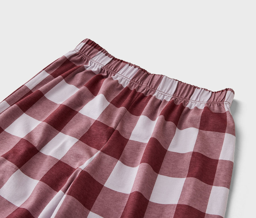 Nahaufnahme einer Hose mit Gummibund und rot-weißem Karomuster.