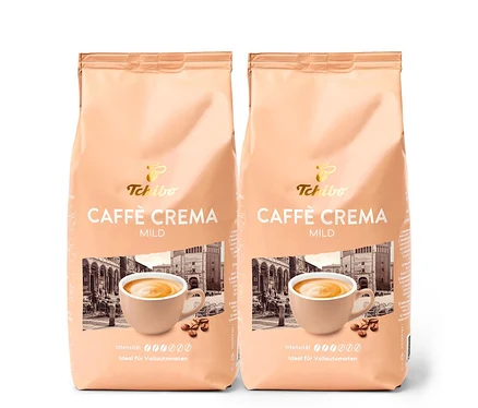 Zwei Packungen Caffè Crema Mild - 2x 1 kg Ganze Bohne von Tchibo. Auf der Packung ist eine Tasse Kaffee und ein Gebäude abgebildet.