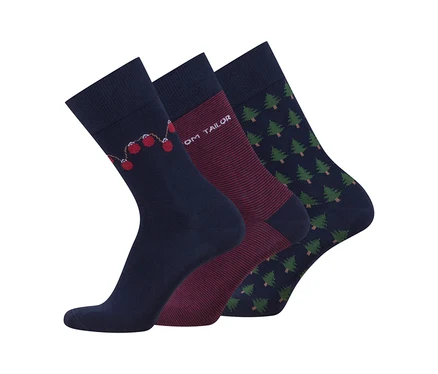 Drei dunkelblaue Socken mit verschiedenen Mustern: eine mit roten Weihnachtskugeln, eine mit dünnen bordeauxroten Streifen und "OM TAILOR"-Schriftzug, und eine mit grünen Weihnachtsbäumen.