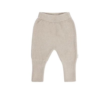 Beige gestrickte Babyhose mit geripptem Bund und Bündchen, auf weißem Hintergrund.