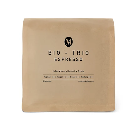 Hellbraune Kaffeepackung METROPOL KAFFEE Bio Trio Espresso mit schwarzem M-Logo und Geschmacksnoten Kakao, Nuss, Karamell, Cremig.