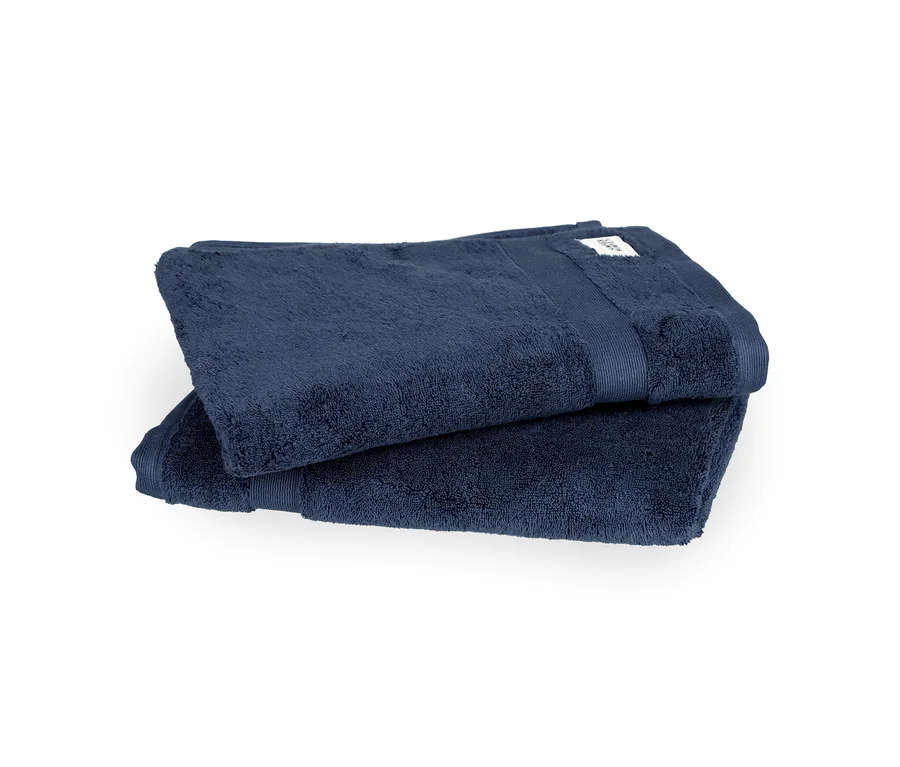 Zwei gefaltete blaue SCHÖNER WOHNEN-Kollektion »Cuddly« Badetücher liegen übereinander.
