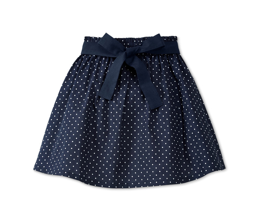 Blauer Rock mit Wendeschürze, weißen Punkten und dunkelblauer Schleife.
