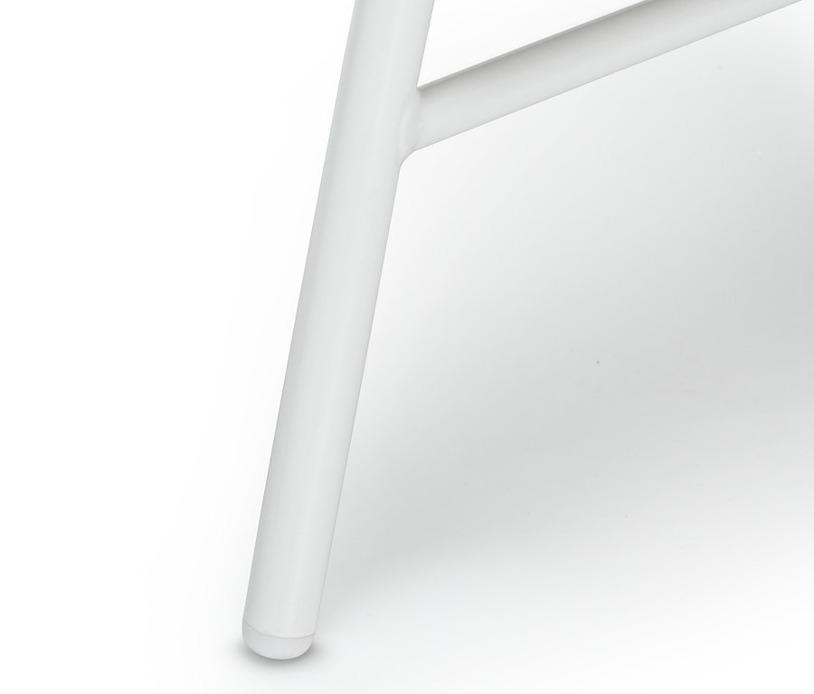 Detailaufnahme eines weißen Beins einer Bank mit Blumenmuster.