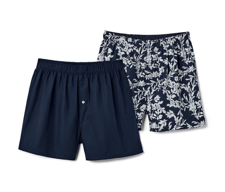 Zwei blaue Web-Boxershorts, eine uni und eine mit Alloverprint.
