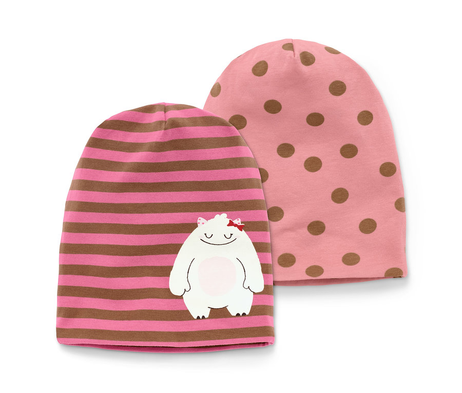Zwei Mützen, eine rosa mit braunen Punkten und eine rosa mit braunen Streifen und einem aufgenähten weißen Monster.
