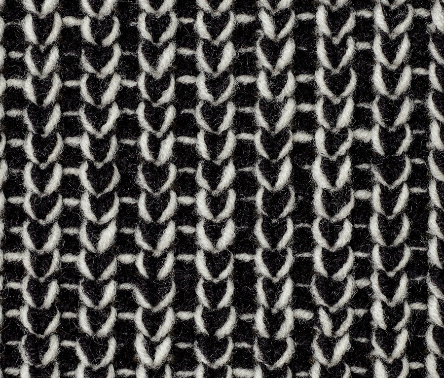 Detailaufnahme eines grob gestrickten Rollkragenpullovers.