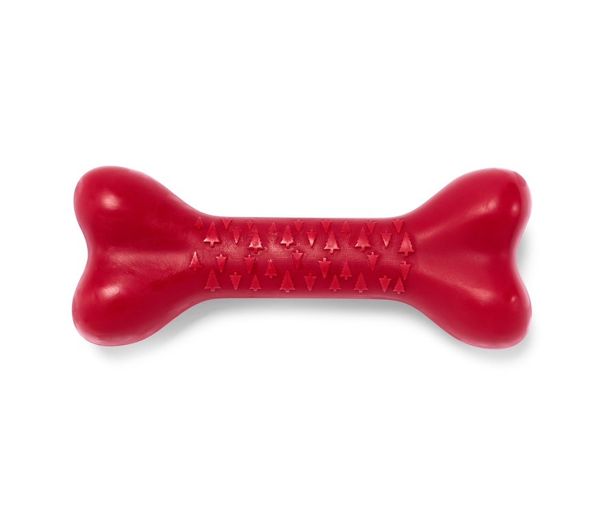Ein rotes Hunde-Spielzeug, Knochen, liegt auf einem weißen Hintergrund.