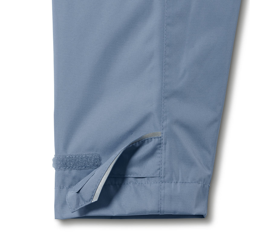 Detailaufnahme einer blauen Unisex-Regenjacke, Fokus auf dem Klettverschluss am Ärmel.