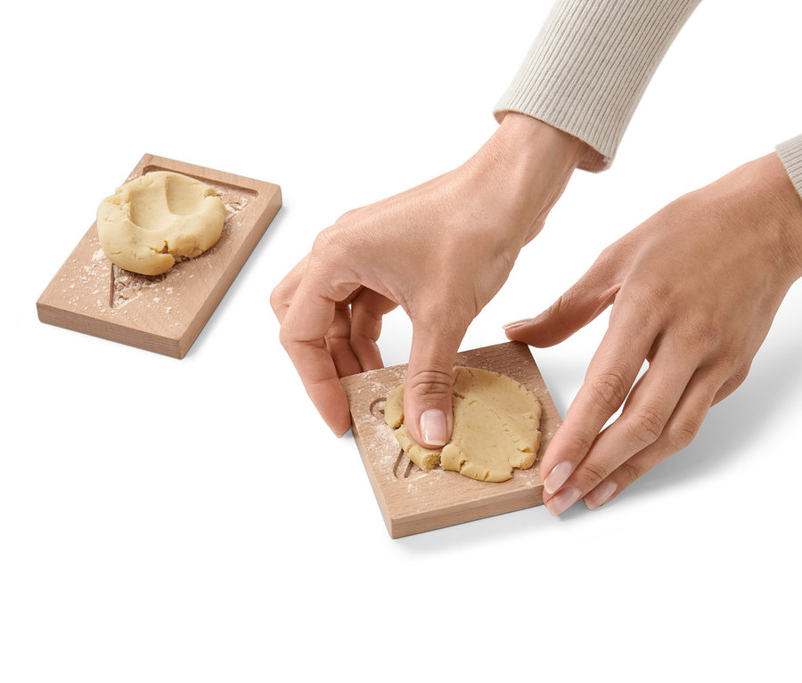 Eine Person drückt Teig in eine von zwei Spekulatiusformen.