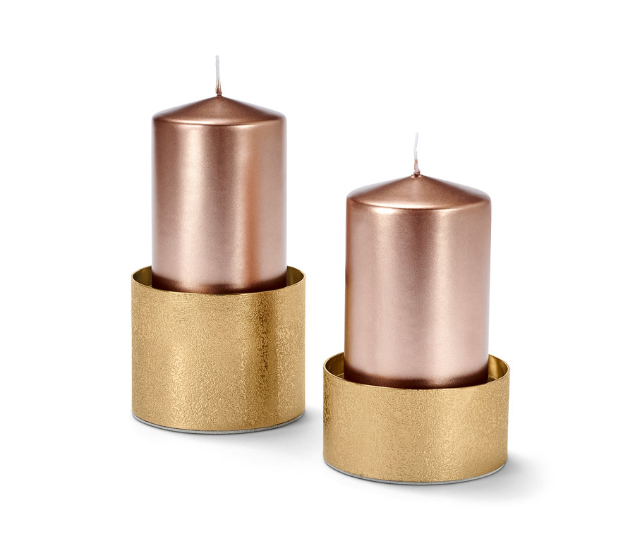 Zwei Kerzenhalter mit roségoldenen Kerzen.