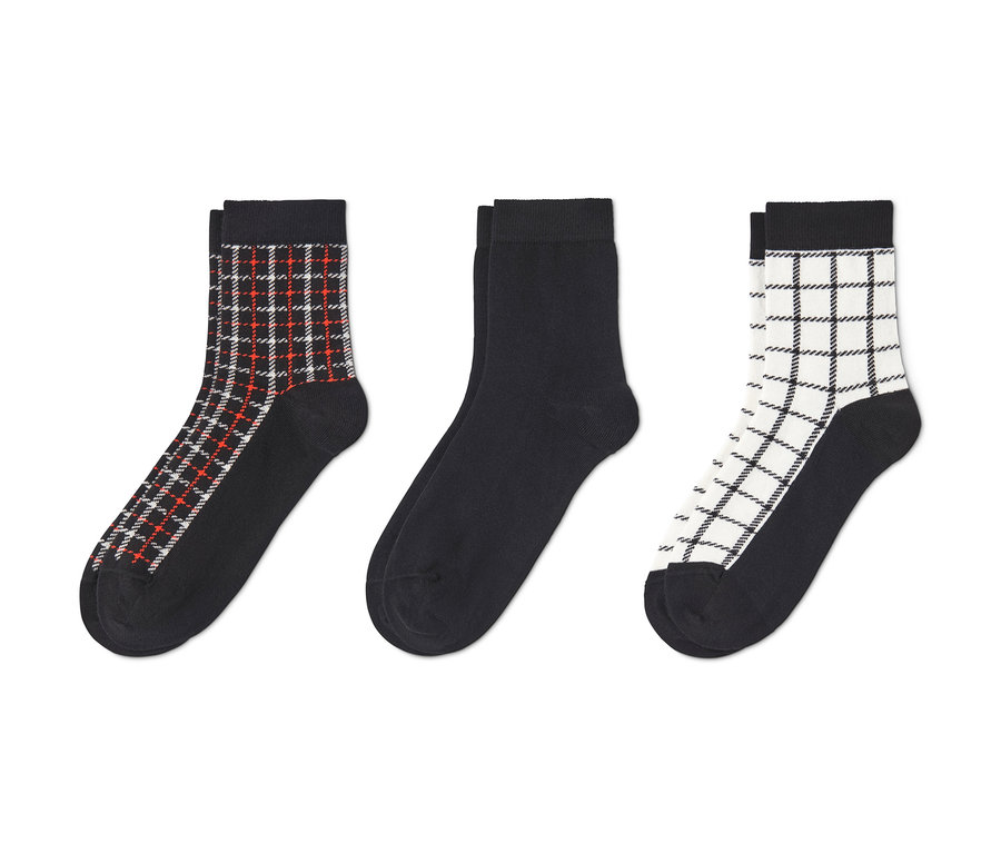 Drei Paar Socken: ein Paar schwarz mit rot-weißem Karomuster, ein Paar schwarz, ein Paar schwarz mit weißem Karomuster.