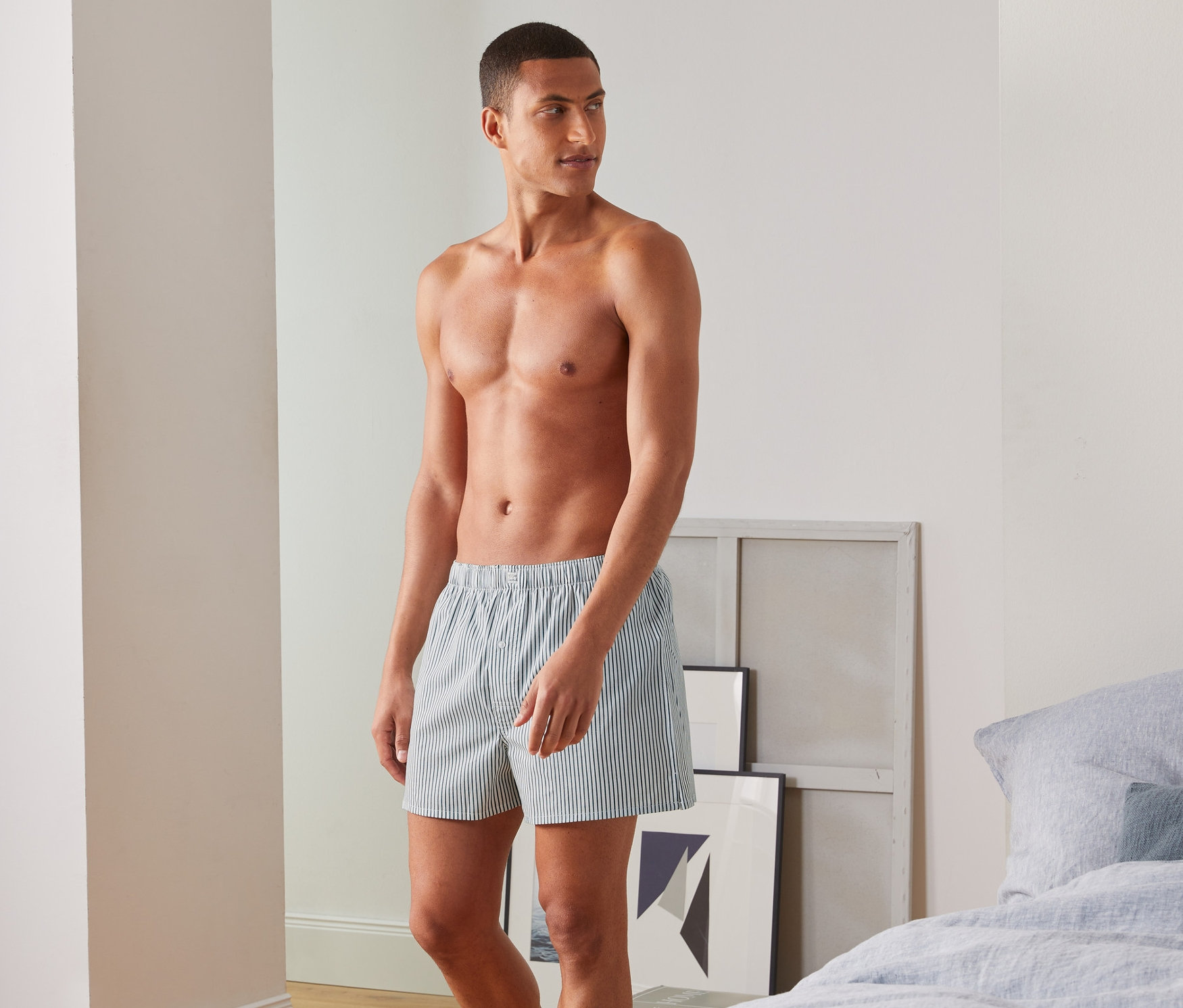 Mann posiert in blau-weiß gestreiften 2 Web-Boxershorts.