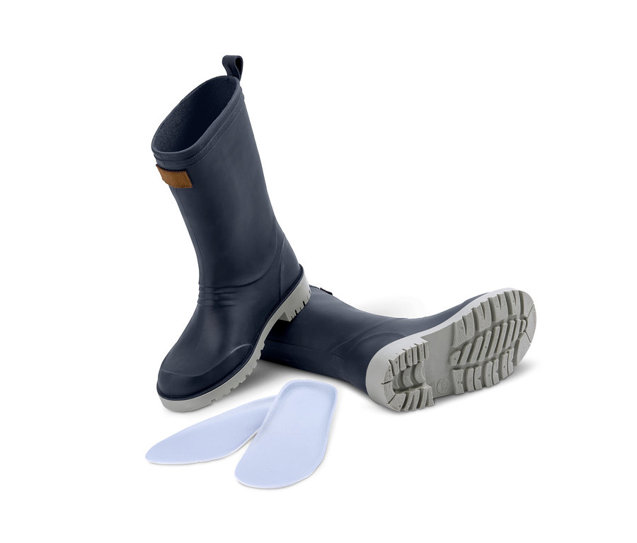 Blaue Gummistiefel und Schuheinlagen liegen auf einem weißen Hintergrund.
