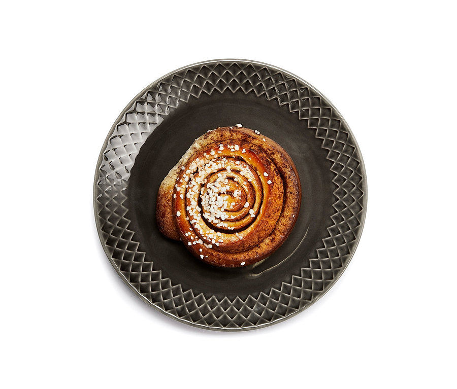 Zimtschnecke mit Zucker bestreut auf einem Dessertteller.