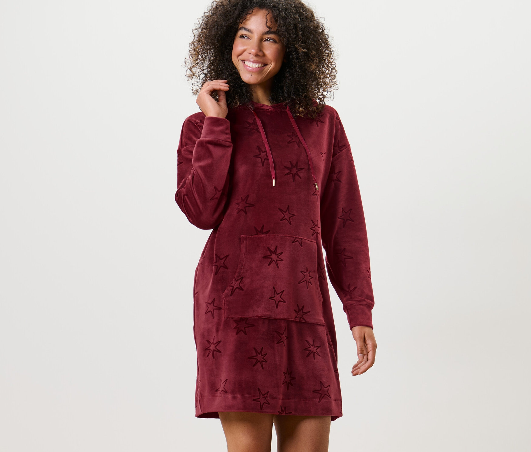 Frau posiert in Nicki-Loungewear-Kleid mit Sternen.