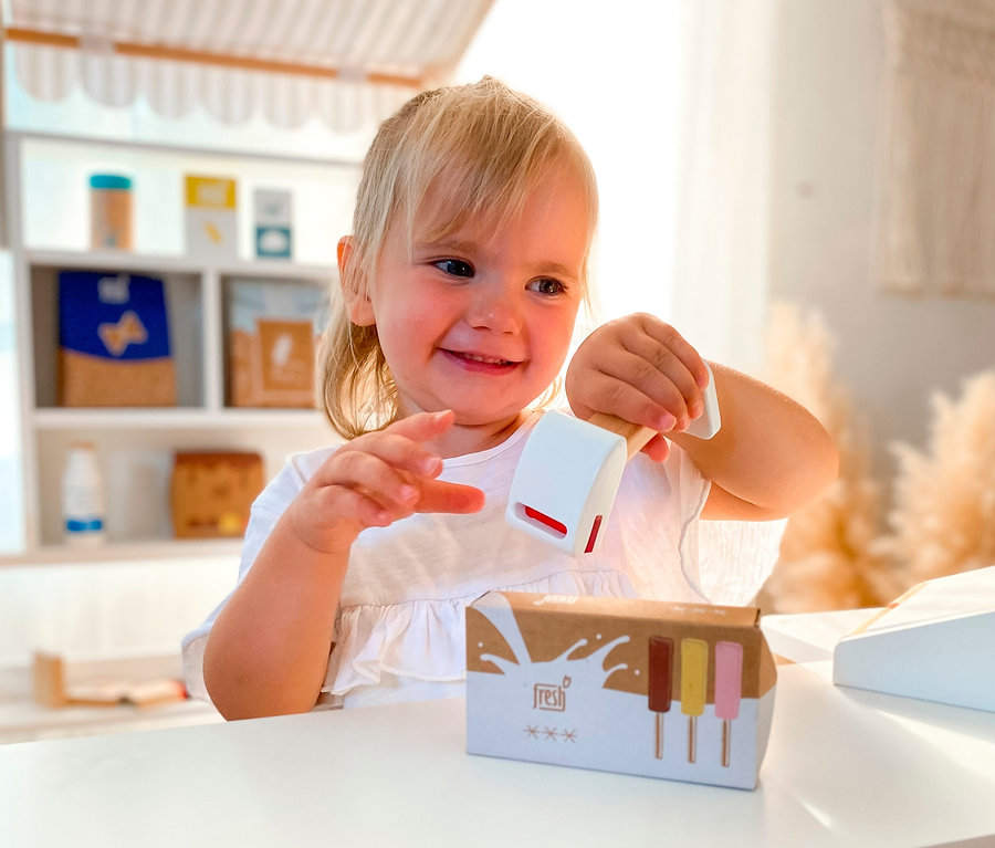 Lächelndes blondes Mädchen spielt mit Spielzeug im small foot Kaufladen kompakt »fresh«.