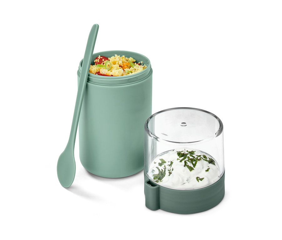Ein grüner To-go-Joghurt-Becher mit Inhalt und Löffel.