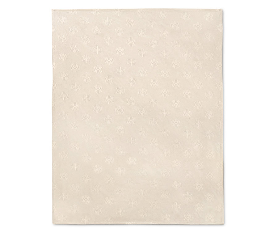 Eine cremefarbene Jacquard-Tischdecke mit Schneeflockenmuster.