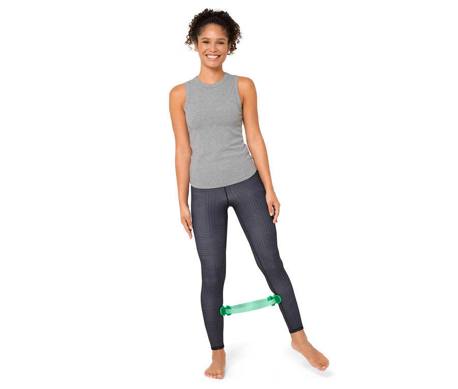 Frau trainiert mit einem Pilatesring zwischen ihren Beinen.