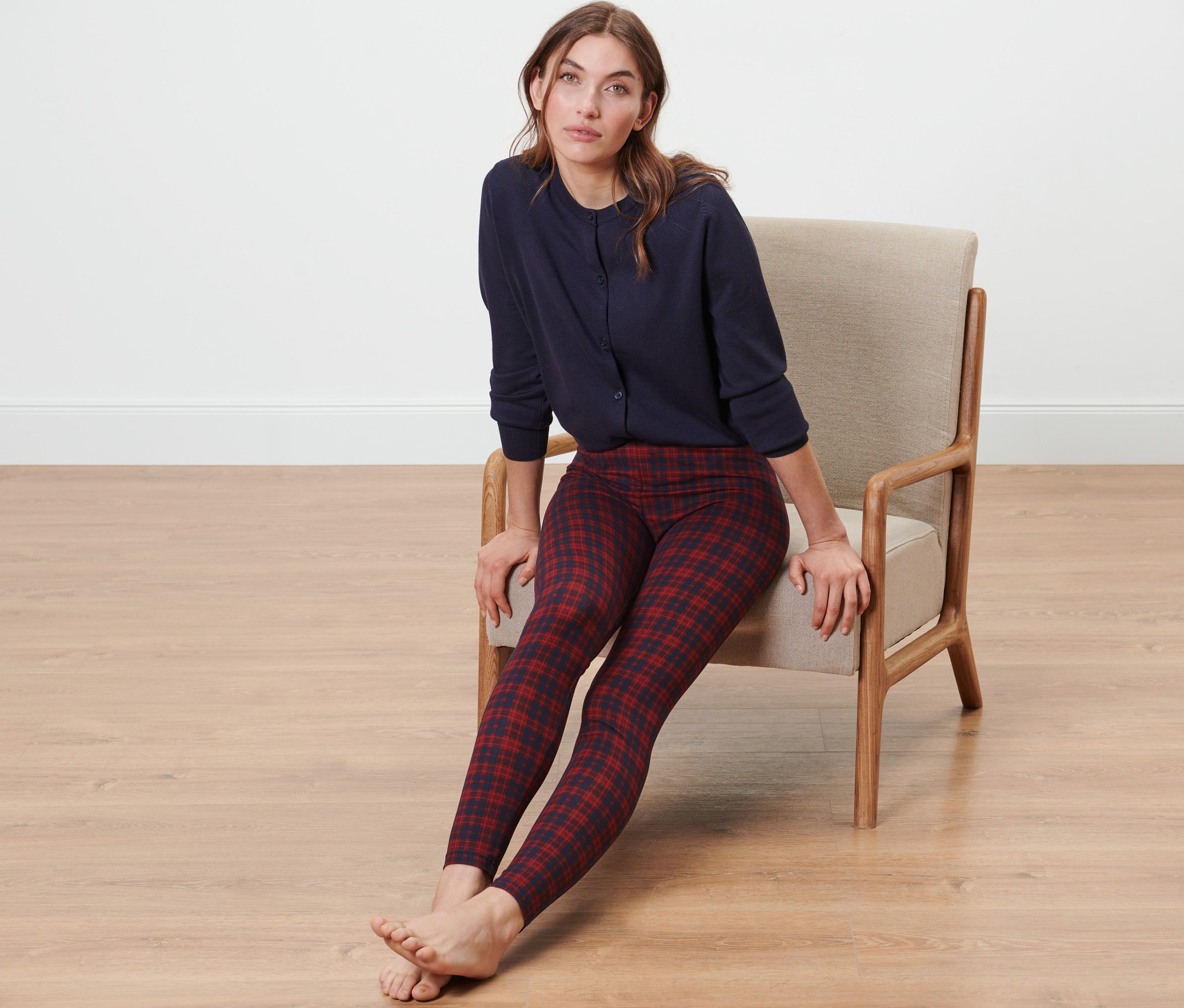 Frau sitzt im Sessel und trägt kuschelige Leggings und ein blaues Oberteil.