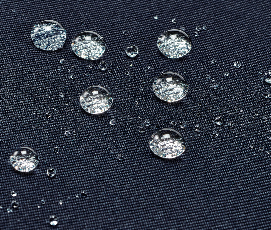 Nahaufnahme von wasserabweisenden Sporttights mit Wassertropfen auf der Oberfläche.