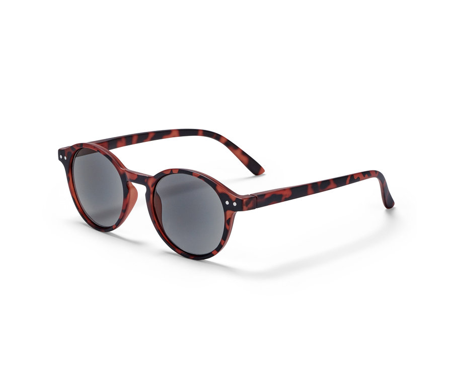 Eine braun-rote Lesebrille mit Tönung und runden, grauen Gläsern liegt auf einer weißen Oberfläche.