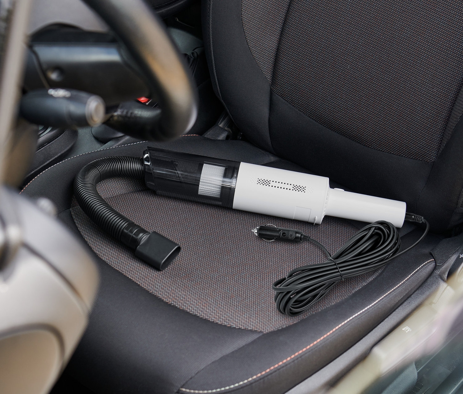 Ein Autostaubsauger liegt auf einem Autositz.