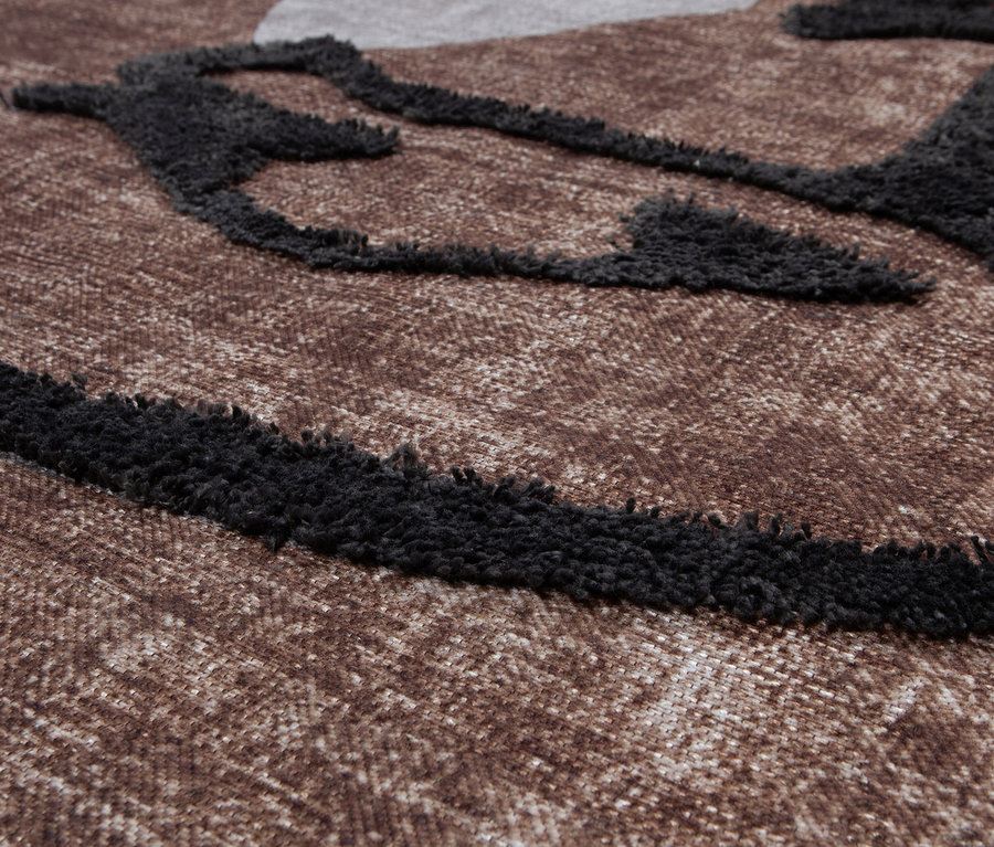 Detailansicht des braunen Woood Teppichs »Roden«, 170 x 240 cm, mit schwarzem abstraktem Muster.