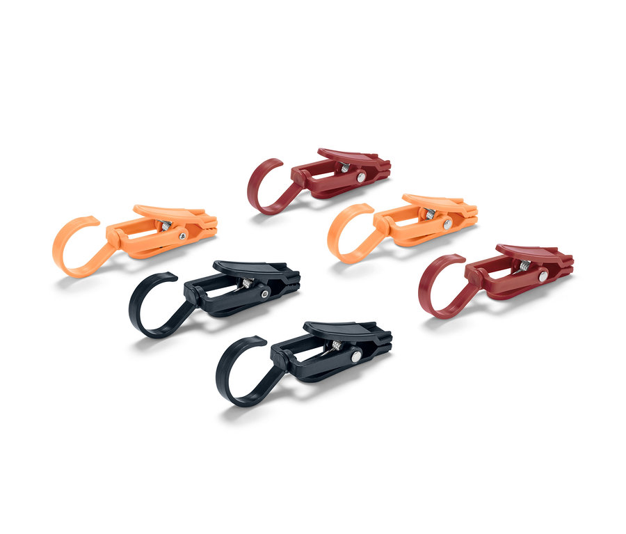 Sechs Outdoor-Clips in Orange, Braun und Schwarz liegen auf einem weißen Hintergrund.