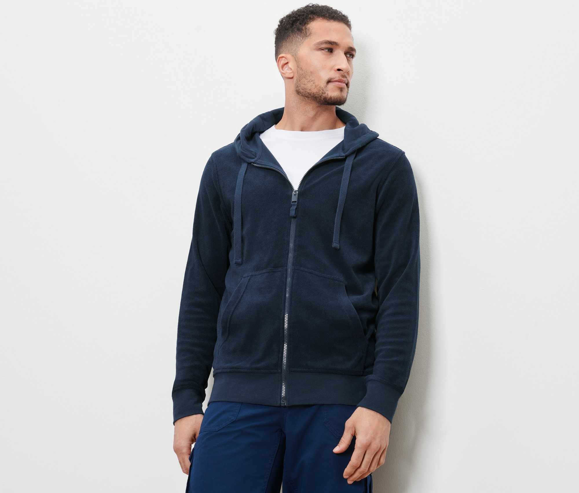 Mann trägt eine blaue Frottee-Kapuzenjacke.