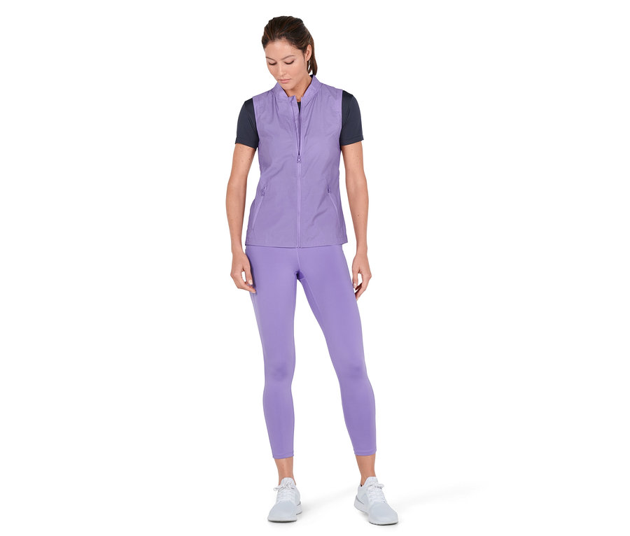 Frau trägt eine lila 3-in-1-Laufjacke, Leggings und Turnschuhe.