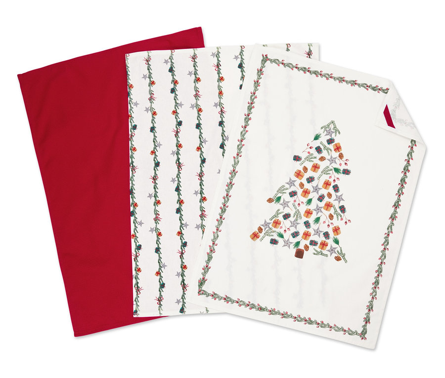 Drei Stoffservietten: eine rote, eine mit Sternenmotiv und eine mit Weihnachtsbaum.
