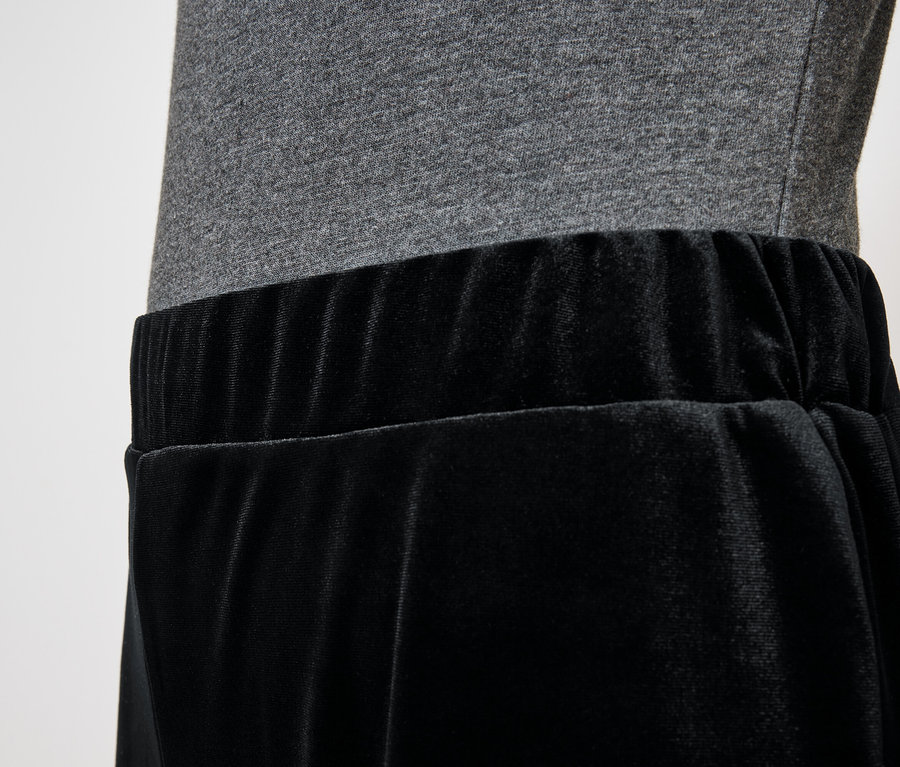 Schwarzer Samtrock mit grauem Oberteil.