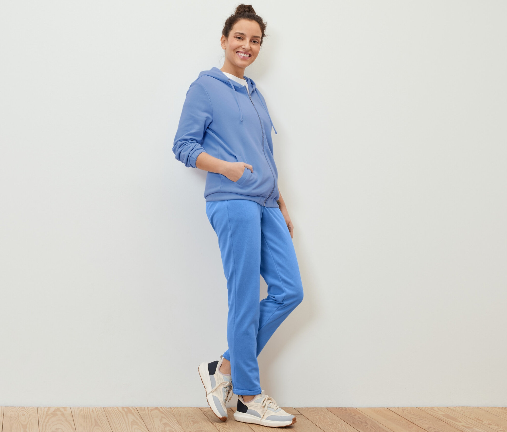 Frau posiert in hellblauer Sweatjacke.