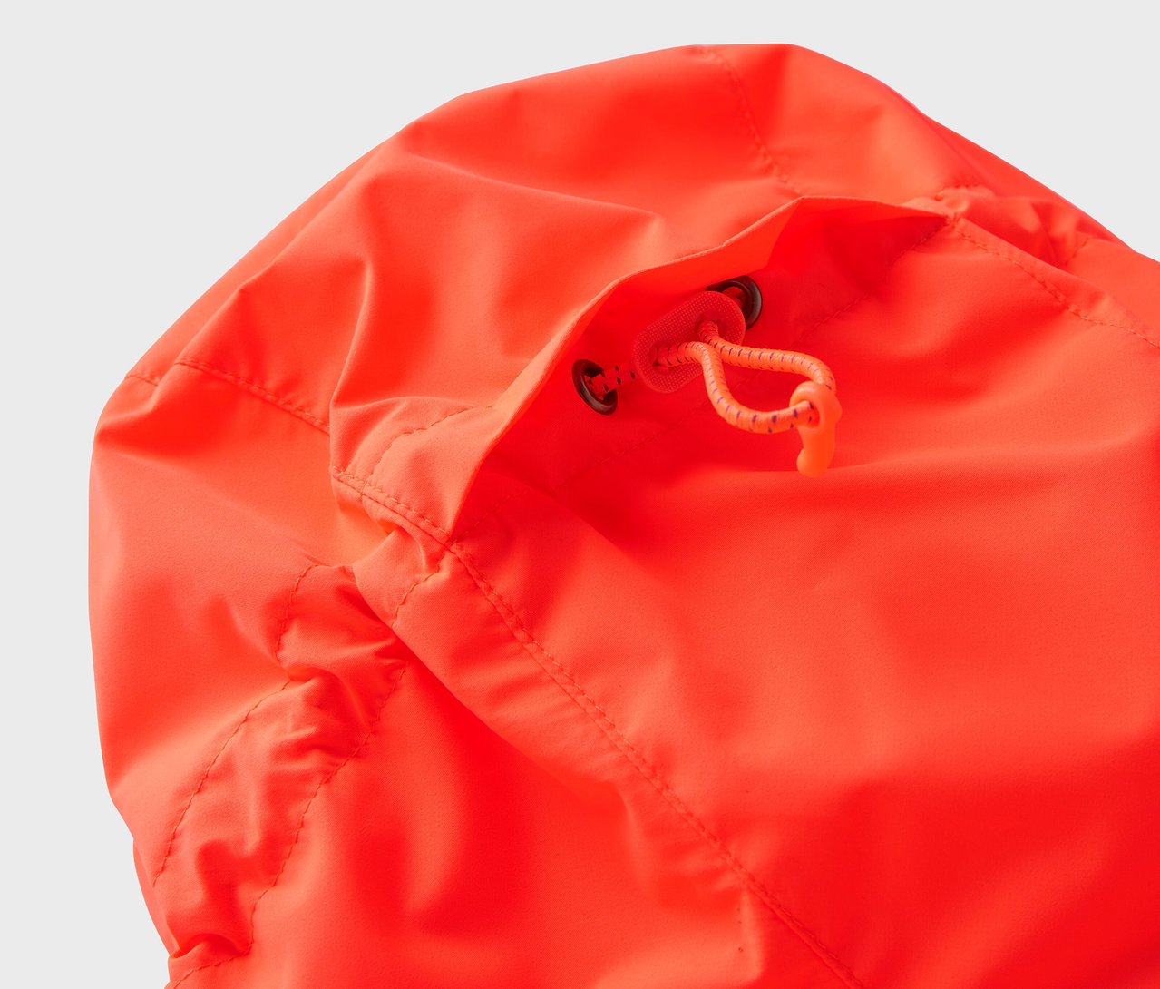 Detailansicht der Kapuze einer orangefarbenen Jacke mit Kordelzug.