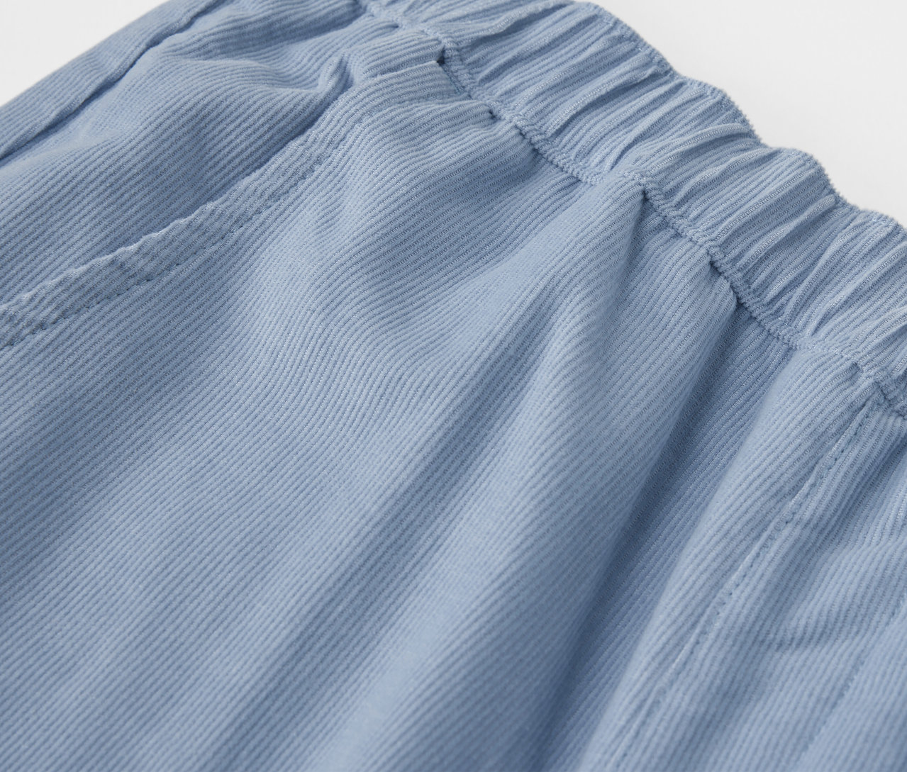 Detailaufnahme einer blauen Kinder-Cord-Outdoorhose mit elastischem Bund.