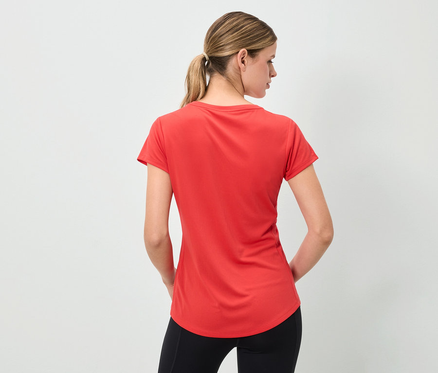 Frau von hinten trägt ein rotes T-Shirt und schwarze Leggings.