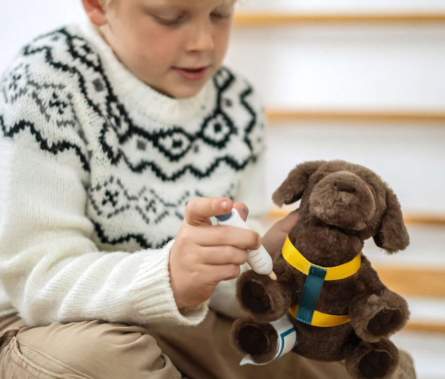 Junge spielt mit small foot Hund mit Tasche und Pflege-Set.