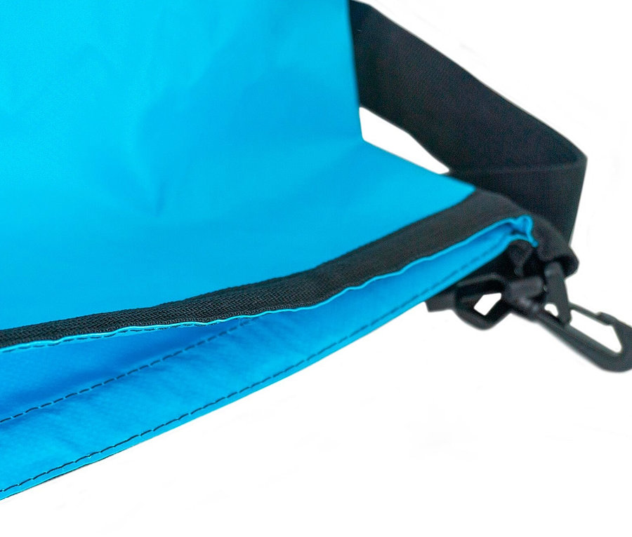 Detailaufnahme eines blauen Spinera Dry Bag 40L mit schwarzem Gurt und Karabiner.
