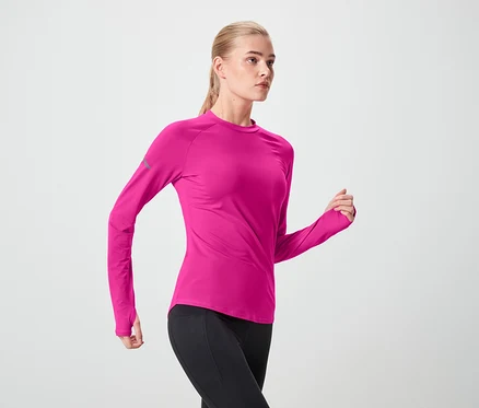 Frau in pinkem Sportoberteil und schwarzen Leggings in Bewegung.