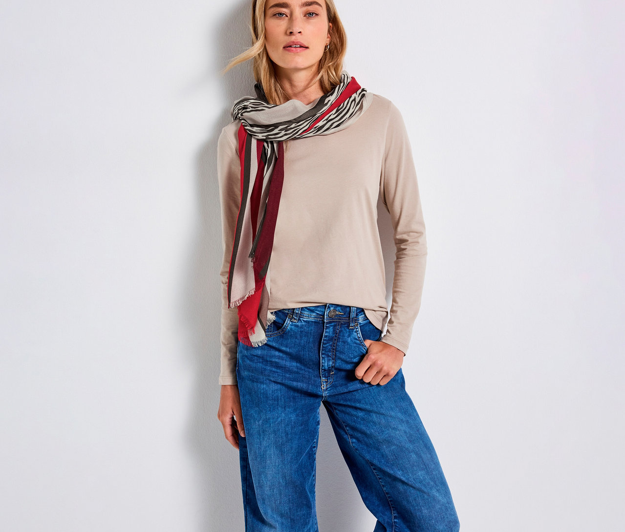 Frau mit beigem Oberteil und blauen Jeans, trägt einen Street One Schal aus Modal.