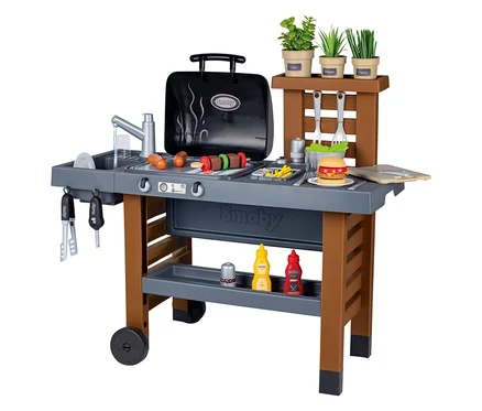 Smoby Outdoor-Gartenküche mit Grill, Spüle, Spiellebensmitteln und Kräutern auf einem Tisch mit Rädern.
