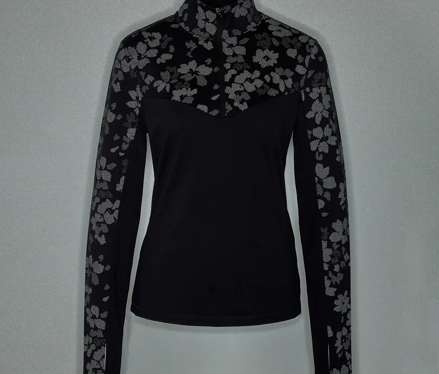 Schwarzes, langärmeliges Shirt mit Reißverschluss und Blumenmuster an Ärmeln und Schultern.