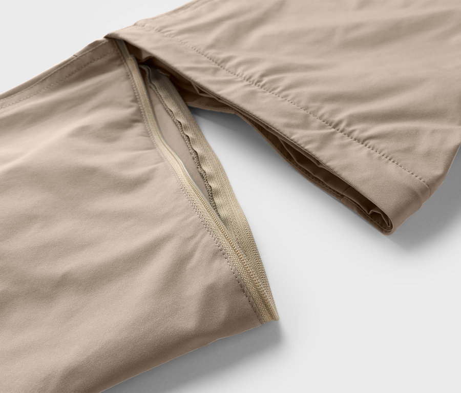 Nahaufnahme einer beigen Hose mit Reißverschlussdetail.