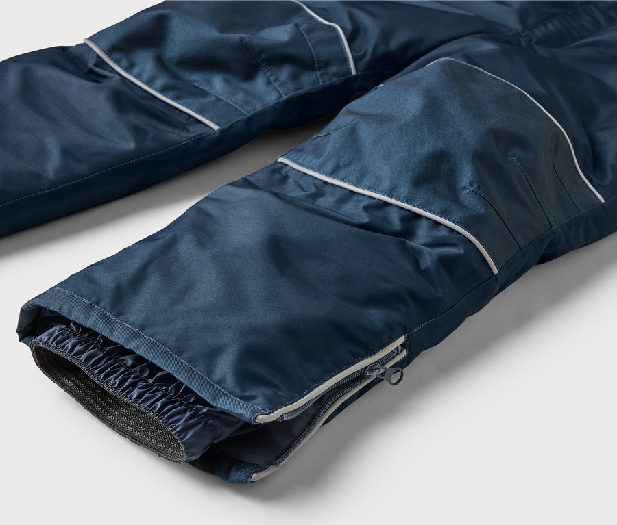 Nahaufnahme einer marineblauen Hose mit weißem Streifen und Reißverschluss am Beinabschluss.